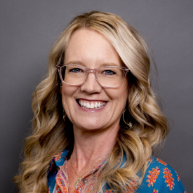 Headshot of Trisha Thomas with a gray background