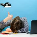 Tired exhausted woman in shirt sitting work sleep laid her head down on office desk with laptop show thumb up gesture ironically